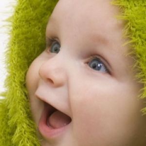 Glückliches Baby in Grüner Kapuze