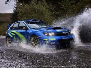 Blaues Rallye-Auto, das Wasser Spritzt