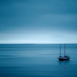Ruhiger Blauer Ozean mit Segelboot