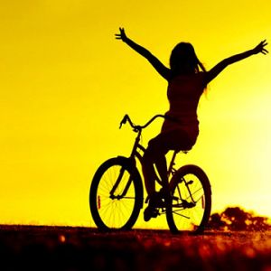 Mädchen auf dem Fahrrad bei Sonnenuntergang