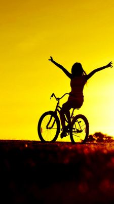 Mädchen auf dem Fahrrad bei Sonnenuntergang