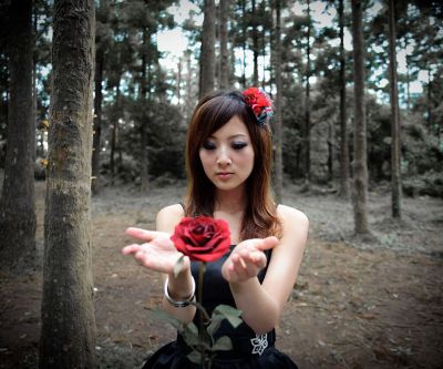 Mädchen mit roter Rose im Wald