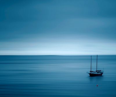 Ruhiger Blauer Ozean mit Segelboot