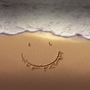 Lächelndes Gesicht im Sand