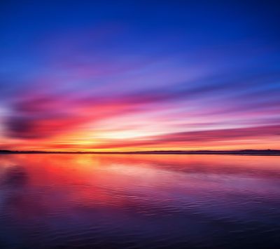 Lebendiger Sonnenuntergang über Wasser