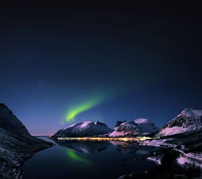 Nordlichter über verschneiten Bergen