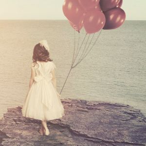 Mädchen mit Ballons am Meer