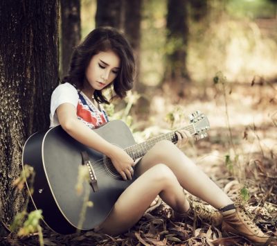 Mädchen Spielt Gitarre in der Natur